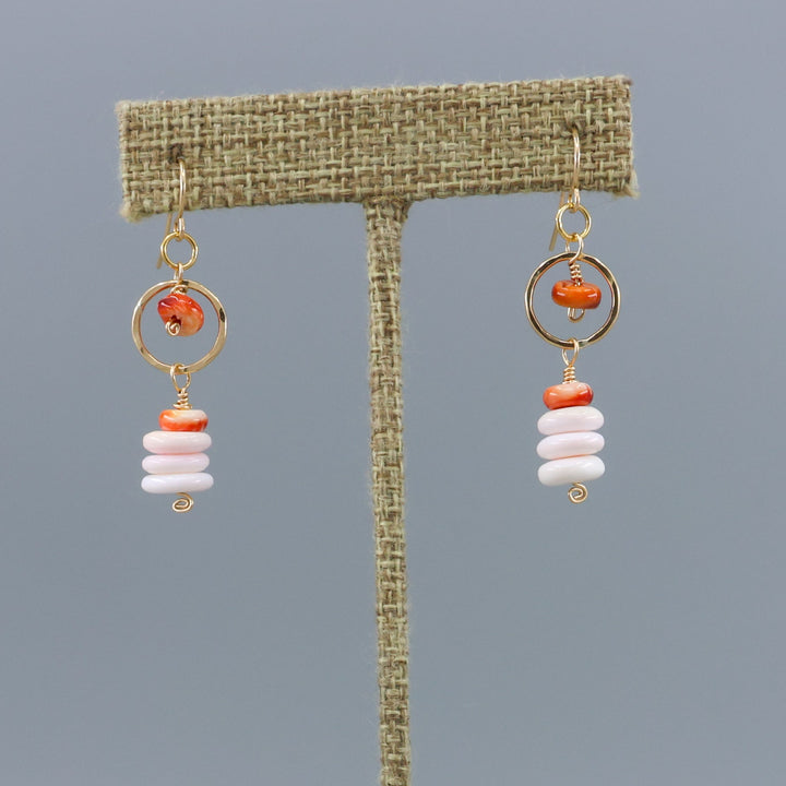 queen conch and spiny oyster gold fill earrings shown on a linen display hanger