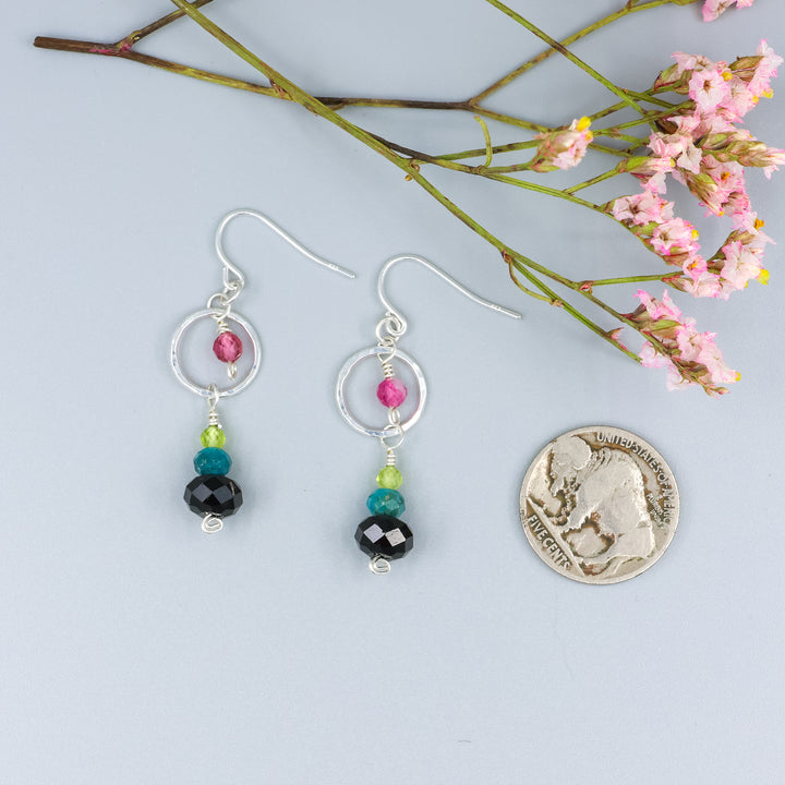handmade gemstone and sterling silver dangle earrings with black tourmaline, blue apatite, peridot, and pink tourmaline with a nickel for size comparison