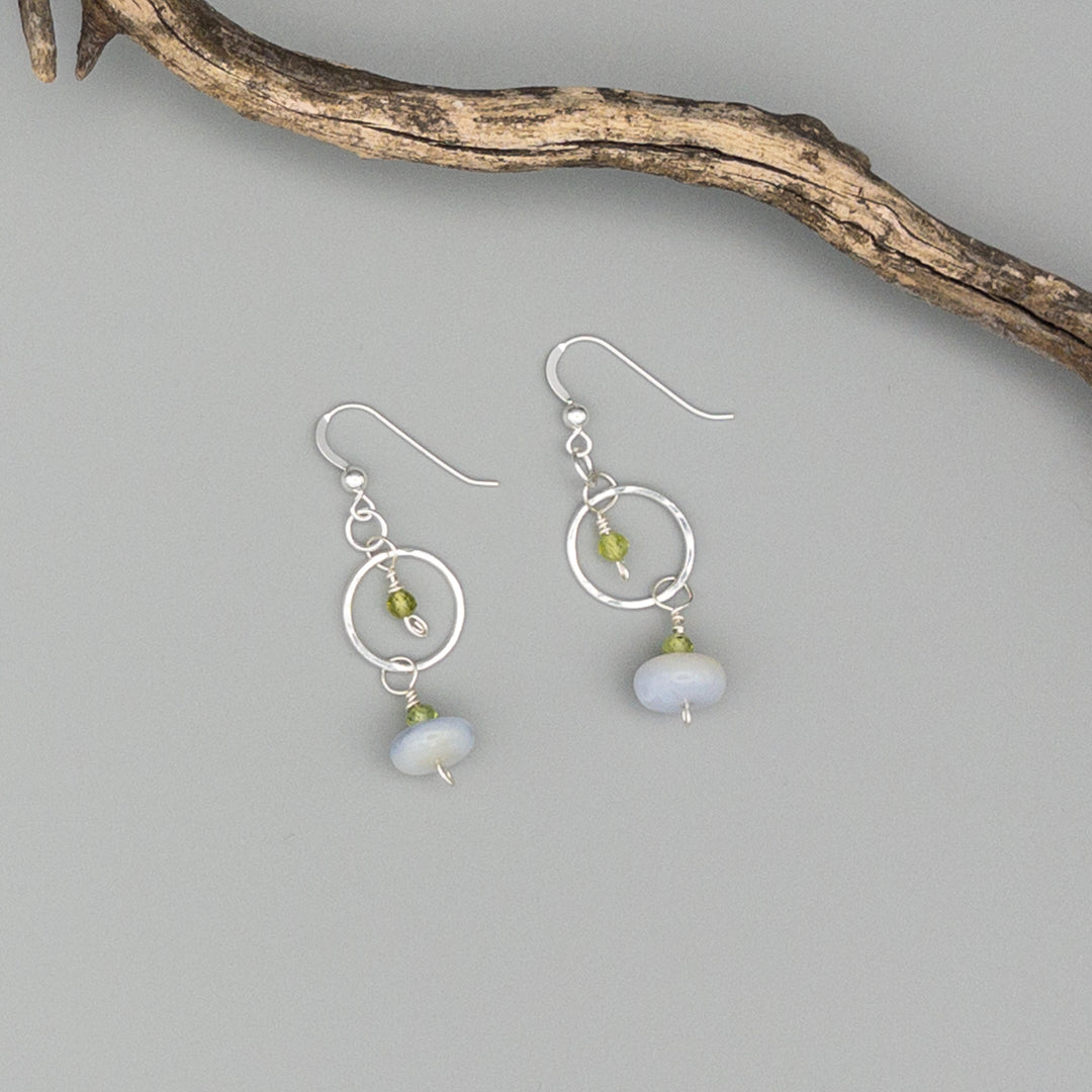 Handmade sterling silver, blue lace agate, and peridot earrings on a gray background