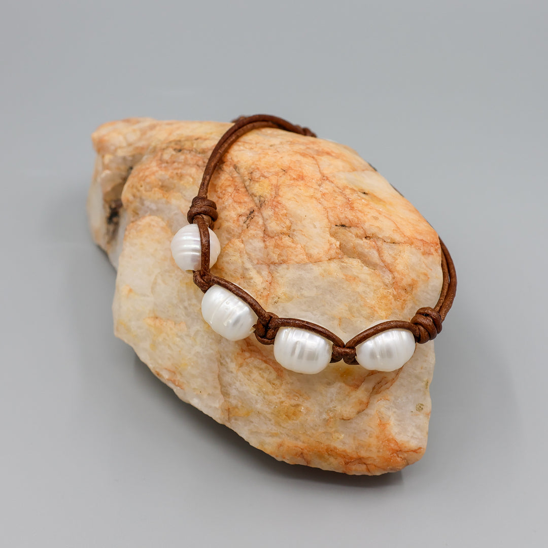 freshwater pearl and leather knotted bracelet on a rock