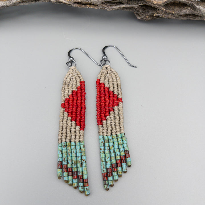 red, tan, and turquoise four elements macrame earrings with seed bead fringe on a gray background