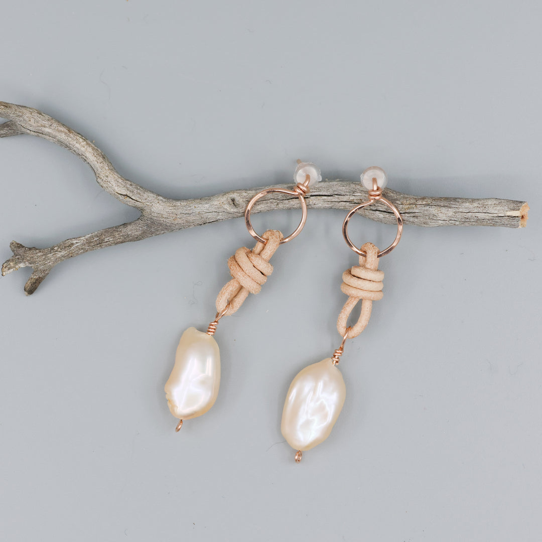 handmade peach freshwater pearl rose gold and leather earrings on a gray background