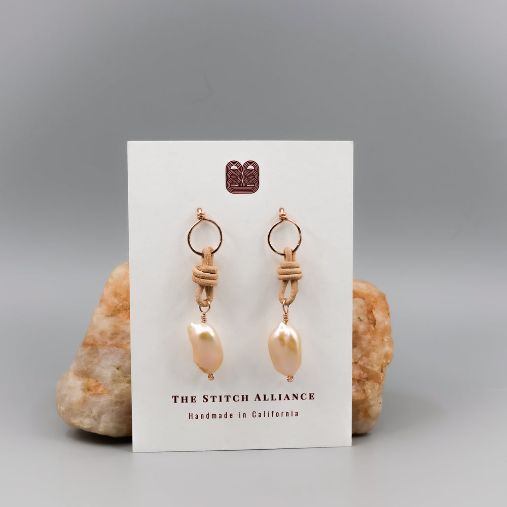 handmade peach freshwater pearl rose gold and leather earrings on a white card