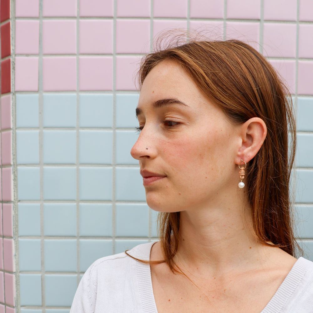 freshwater pearl and leather gold filled earrings worn on a model