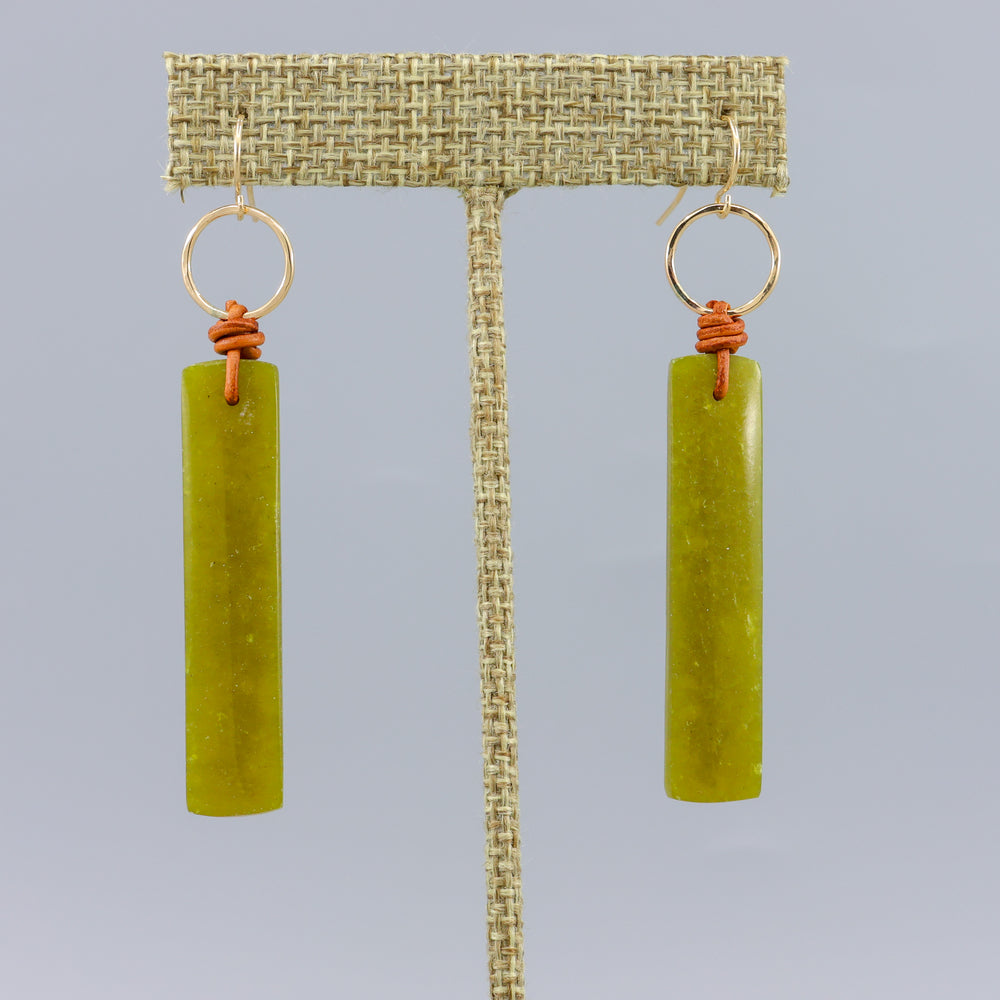 handmade african jade, leather, and gold fill earrings on a gray background