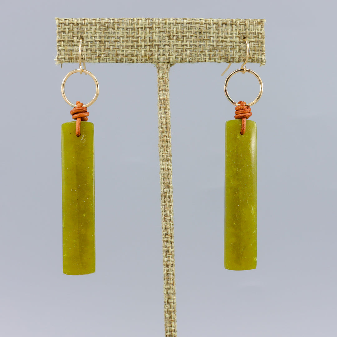 handmade african jade, leather, and gold fill earrings on a gray background