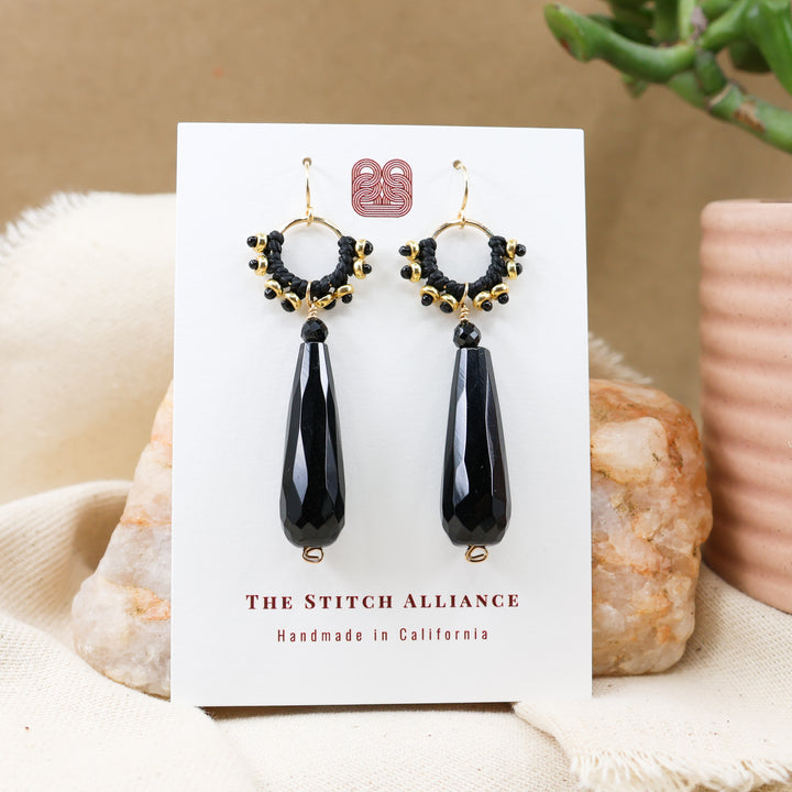 black onyx and gold statement earrings shown on a white card