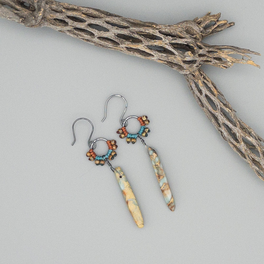 aqua terra jasper statement earrings on a gray background