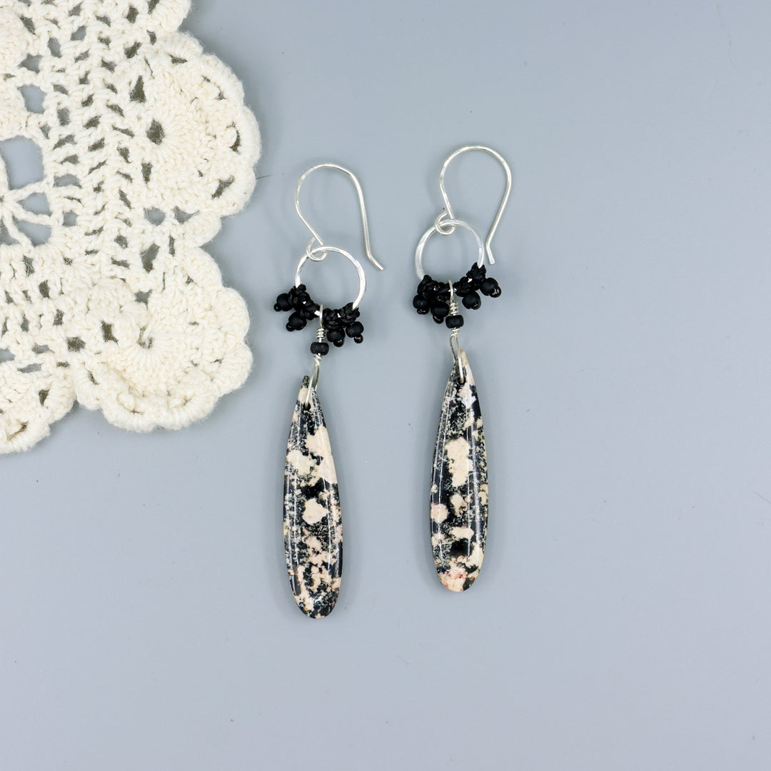 handmade snowflake obsidian sterling silver macrame earrings on a gray background