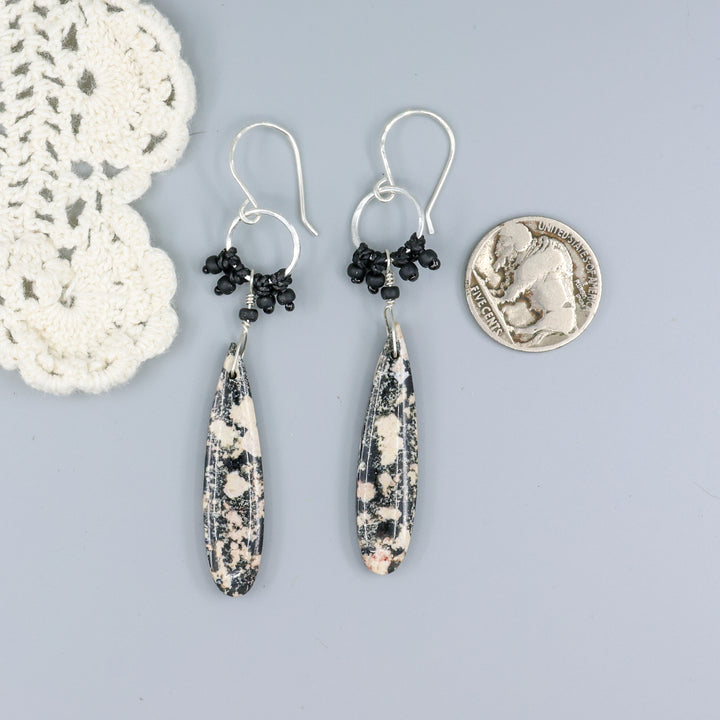 handmade snowflake obsidian sterling silver macrame earrings with a nickel for size comparison