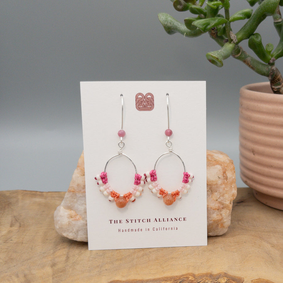 sterling silver pink macrame hoop earrings with sunstone bead on a white card