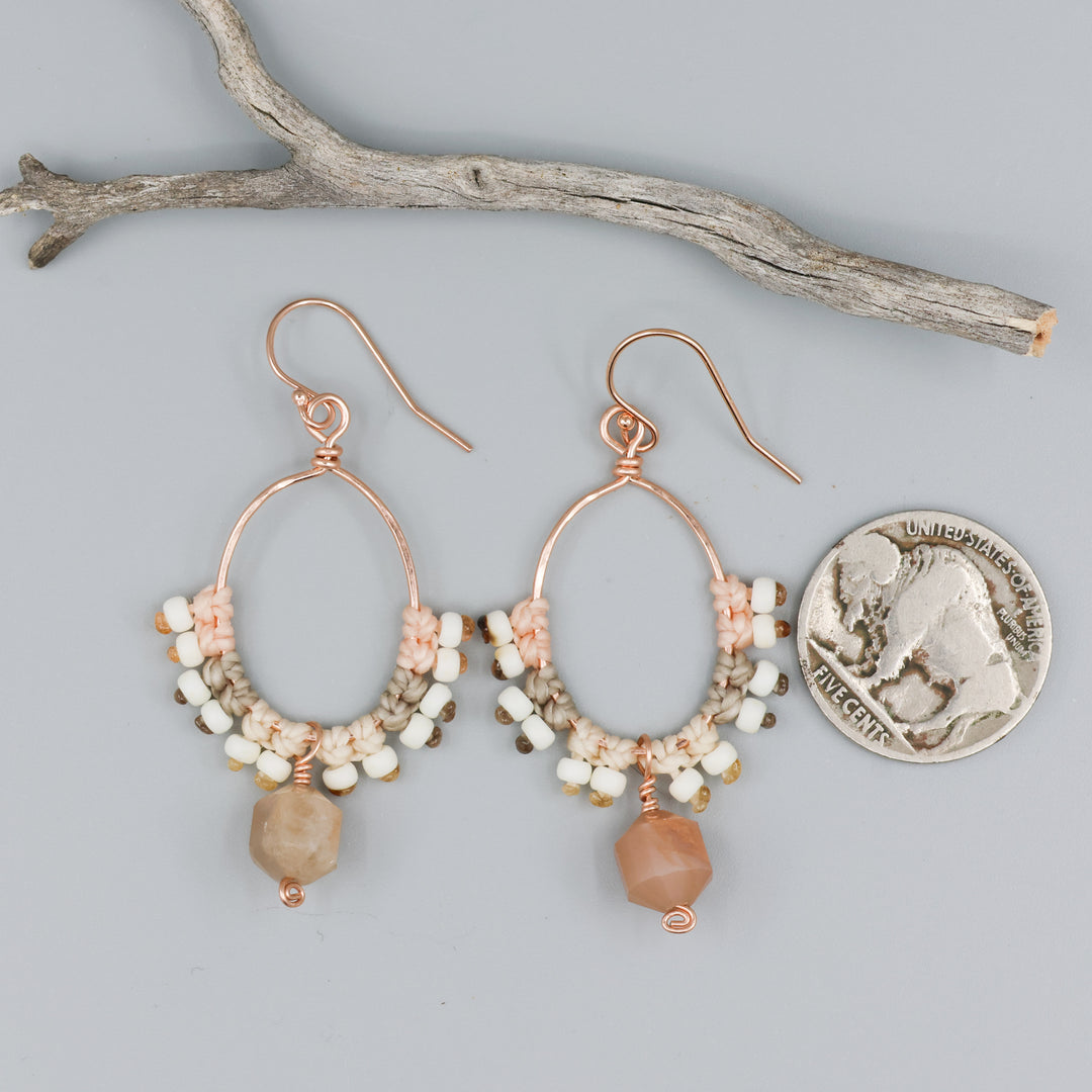 peach moonstone & rose gold macrame hoop earrings with a coin for size comparison