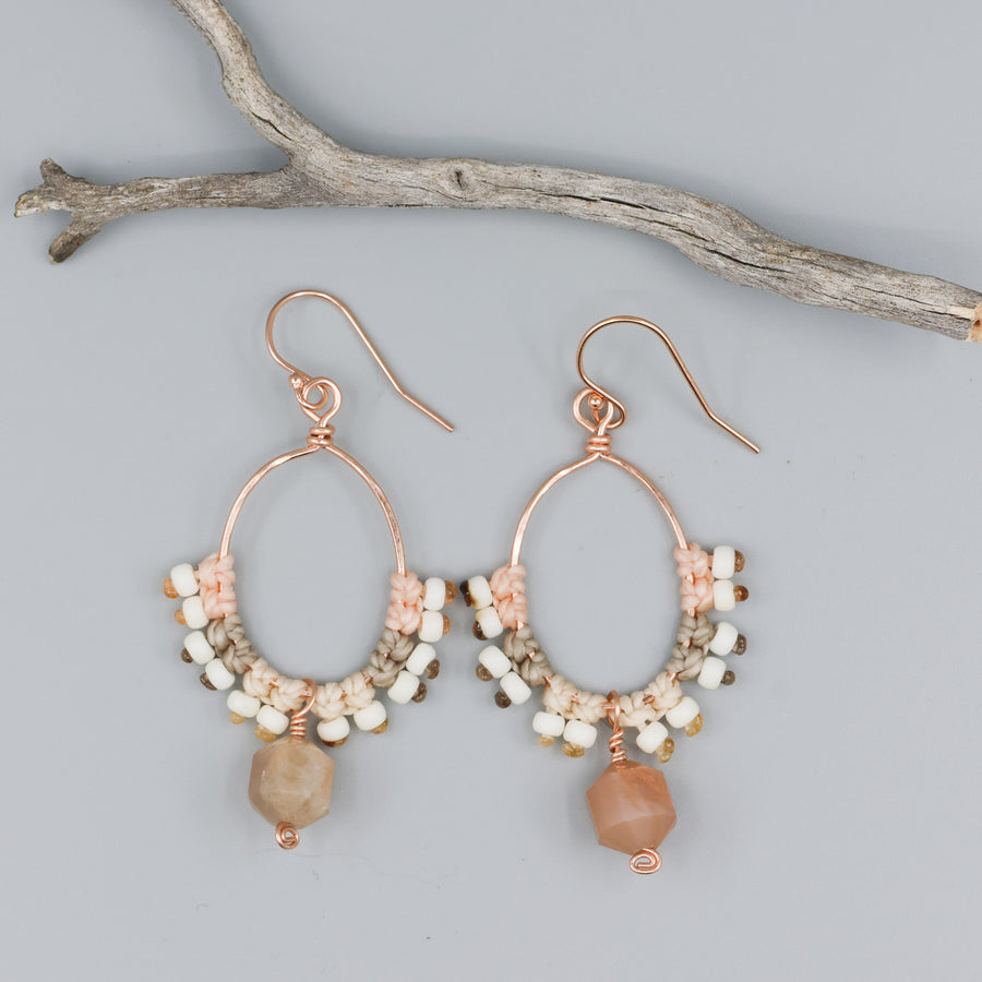 peach moonstone & rose gold macrame hoop earrings on a gray background