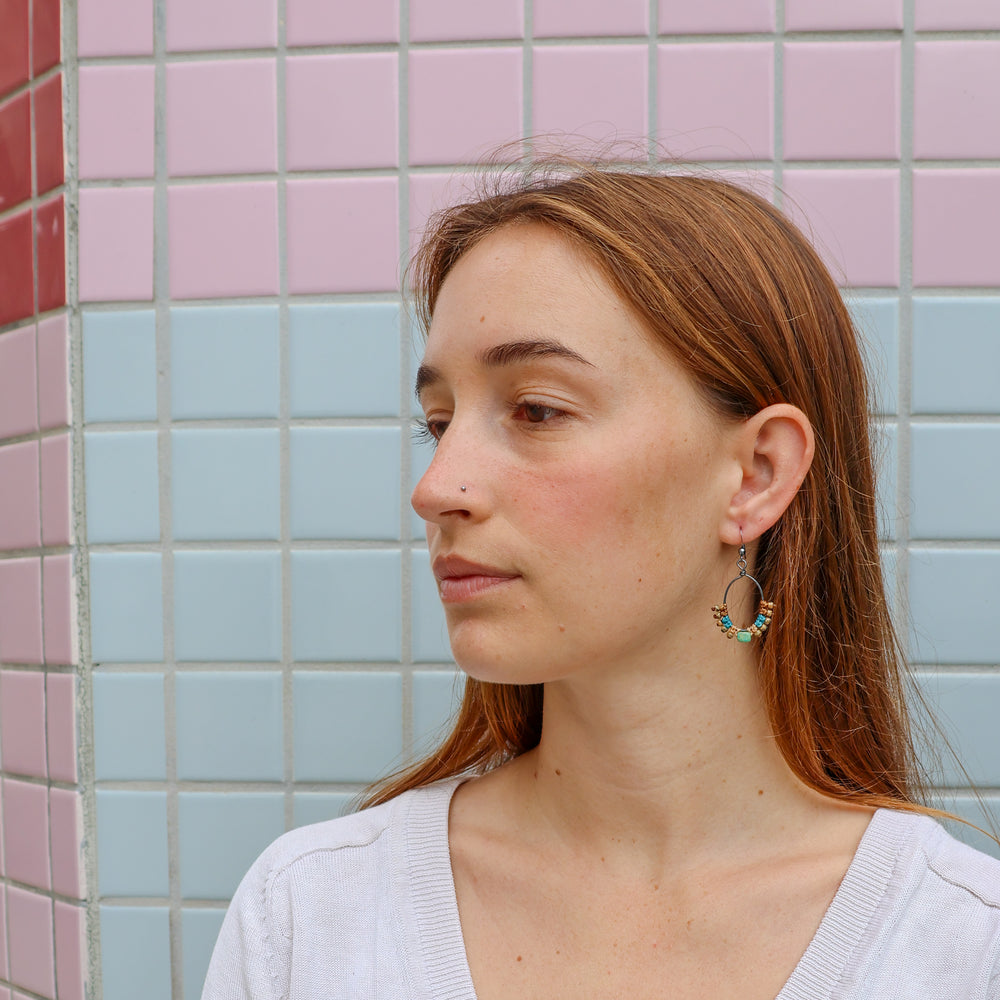 handmade macrame hoop earrings with turquoise bead worn on a model
