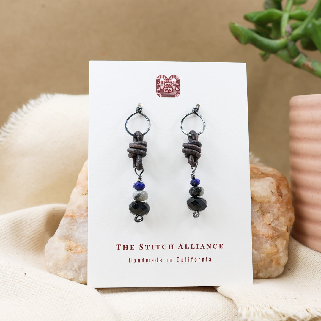 black tourmaline, larvikite, and lapis lazuli oxidized sterling silver earrings on a white card