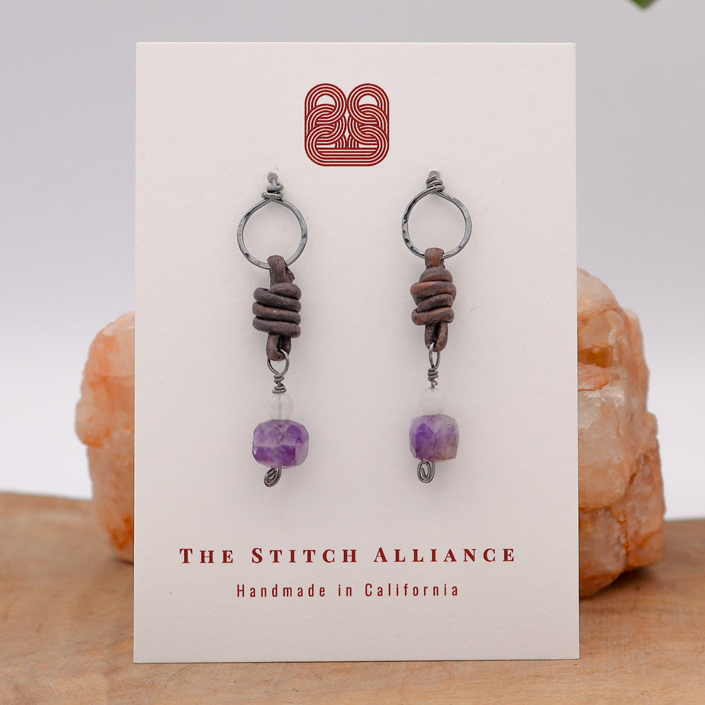 leather, amethyst, and moonstone oxidized sterling silver earrings on a white card