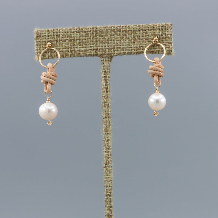 freshwater pearl, leather, and gold fill handmade earrings on a linen hanger