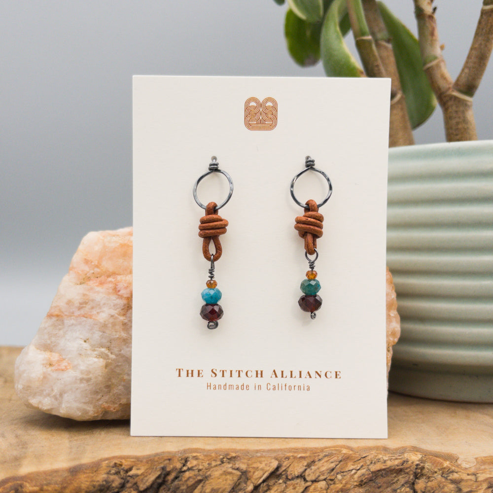 garnet, blue apatite, hessonite bead earrings with leather and oxidized sterling silver on a white card