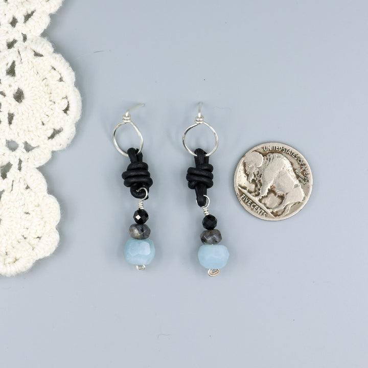 handmade aquamarine, larvakite, and black spinel leather & sterling silver earrings with a nickel for size comparison
