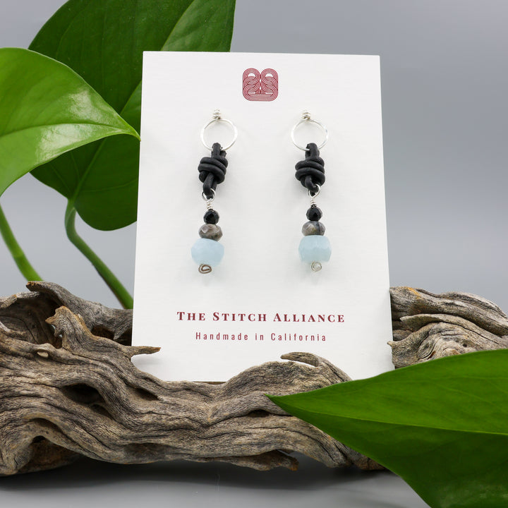 handmade aquamarine, larvakite, and black spinel leather & sterling silver earrings on a white card