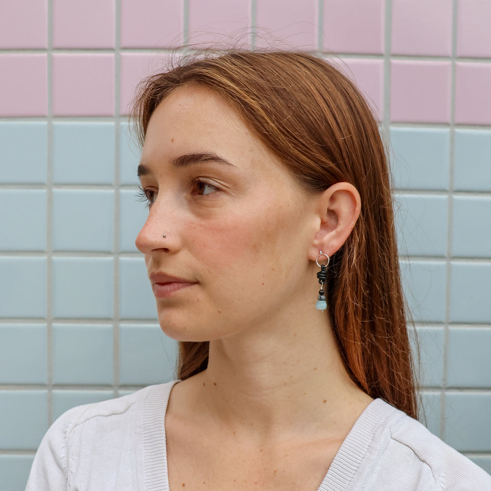aquamarine, larvikite, and black spinel sterling silver earrings worn on a model