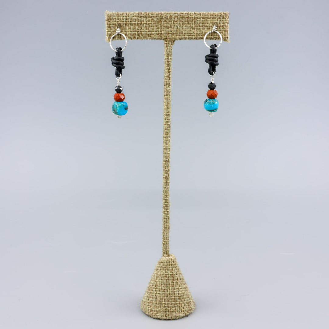 turquoise, poppy jasper, and spinel leather knotted earrings with sterling silver on a linen hanger