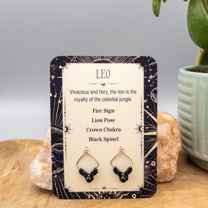 Leo black spinel gold filled earrings on a gift card