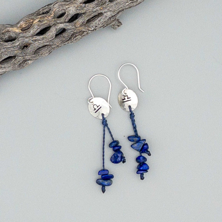 Libra zodiac earrings hand stamped sterling silver with lapis lazuli beads on a gray background