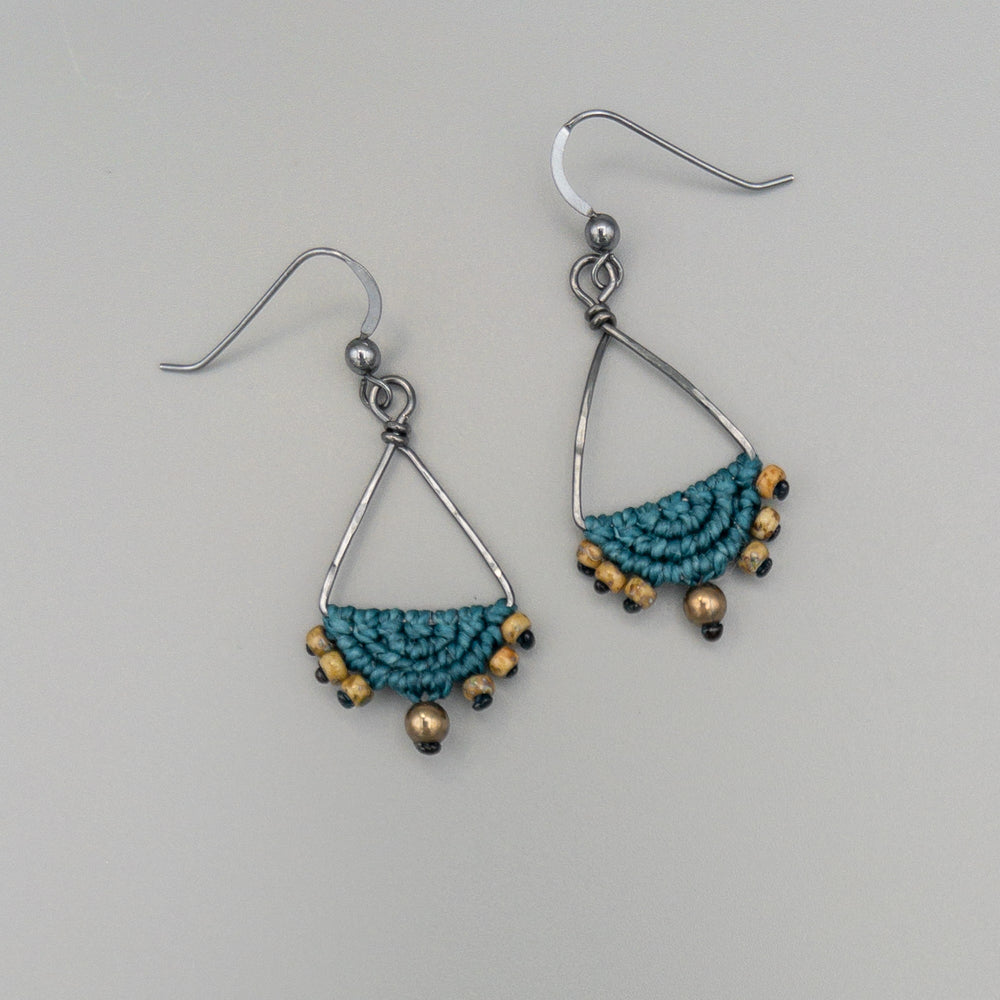 teal macrame triangle hoop earrings in oxidized sterling silver on a gray background