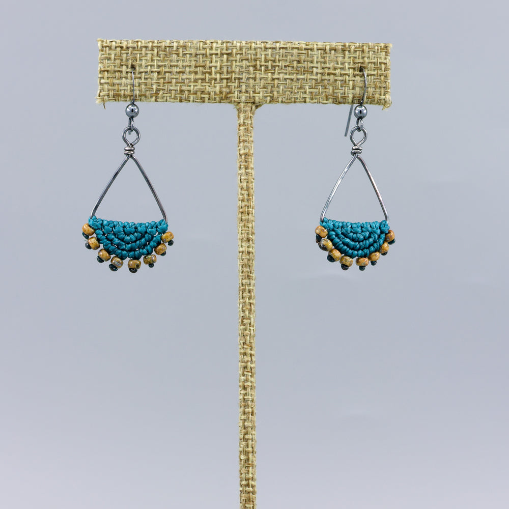 handmade macrame triangle hoop earrings oxidized sterling silver teal color on a gray background