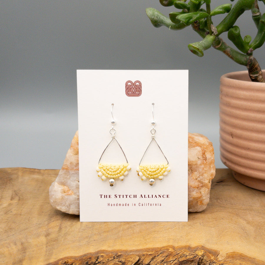 yellow macrame triangle hoop sterling silver earrings on a white card