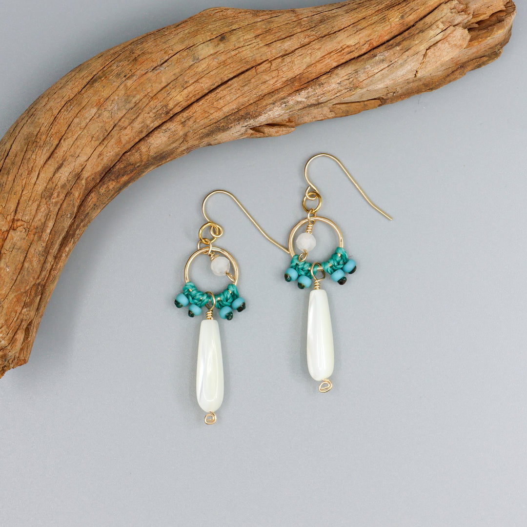 mother of pearl macrame earrings in 14k gold fill on a gray background