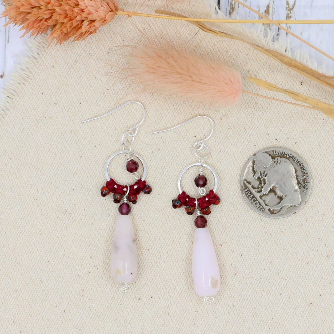 handmade sterling silver earrings with pink opal, garnet, and macrame shown with a coin for size comparison