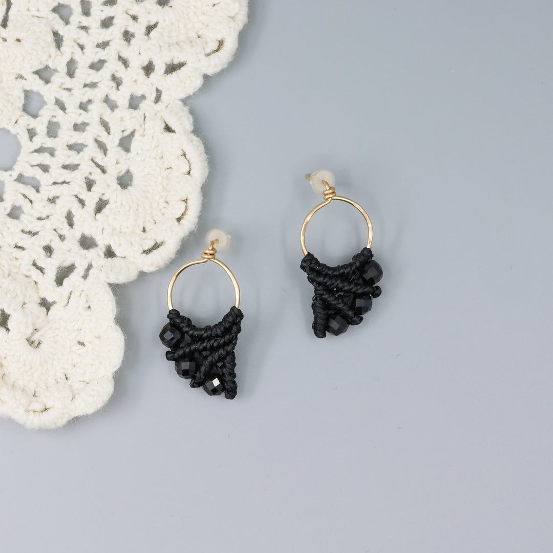 handmade gold fill macrame earrings with black spinel beads on a gray background