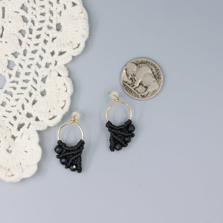 handmade gold fill macrame earrings with black spinel beads with a nickel for size comparison