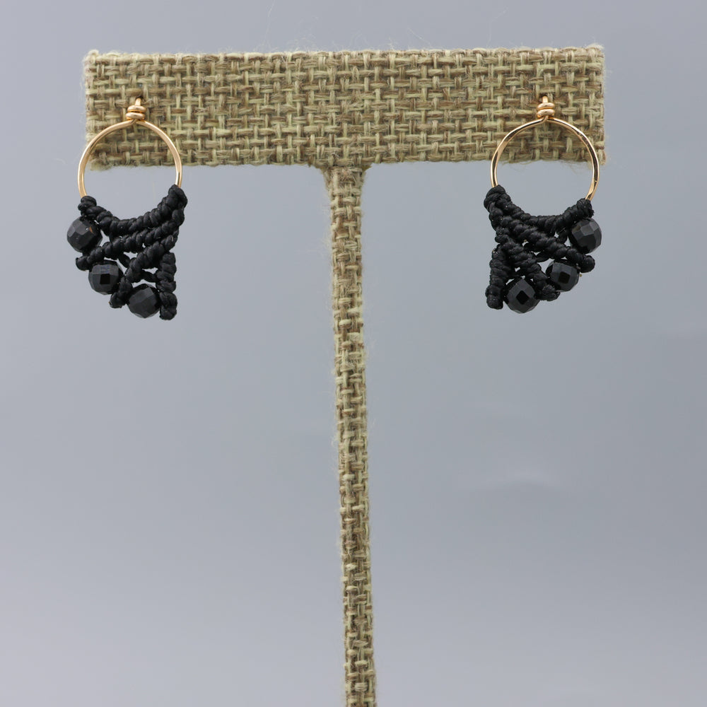handmade gold fill macrame earrings with black spinel beads on a linen hanger