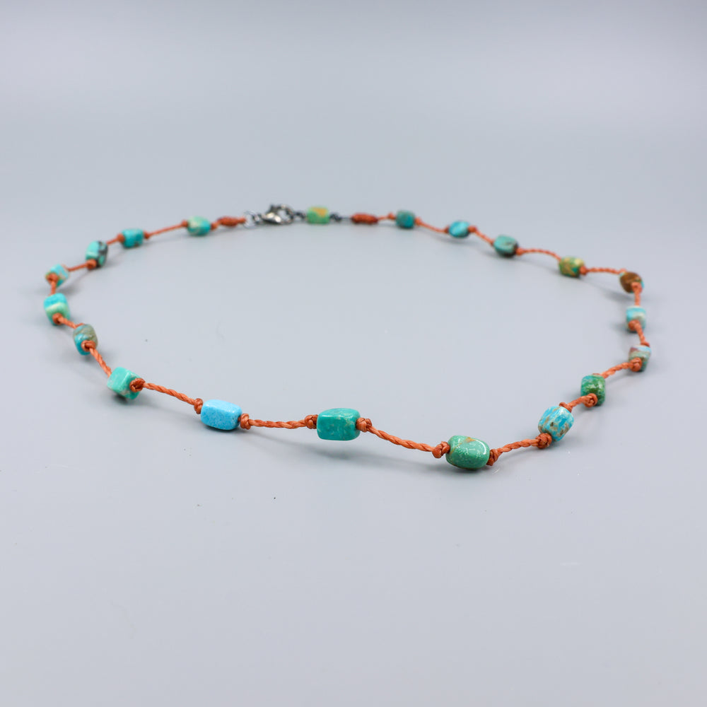 close up view of a Handmade turquoise bead necklace on hand knotted terracotta cord with an oxidized sterling silver clasp