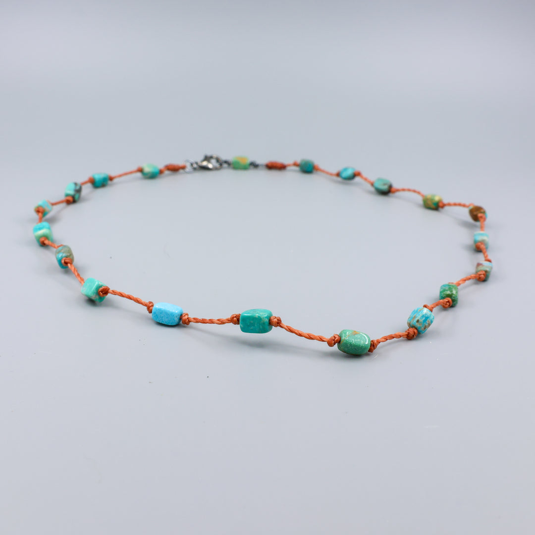 close up view of a Handmade turquoise bead necklace on hand knotted terracotta cord with an oxidized sterling silver clasp