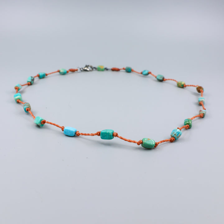 close up view of a Handmade turquoise bead necklace on hand knotted terracotta cord with an oxidized sterling silver clasp