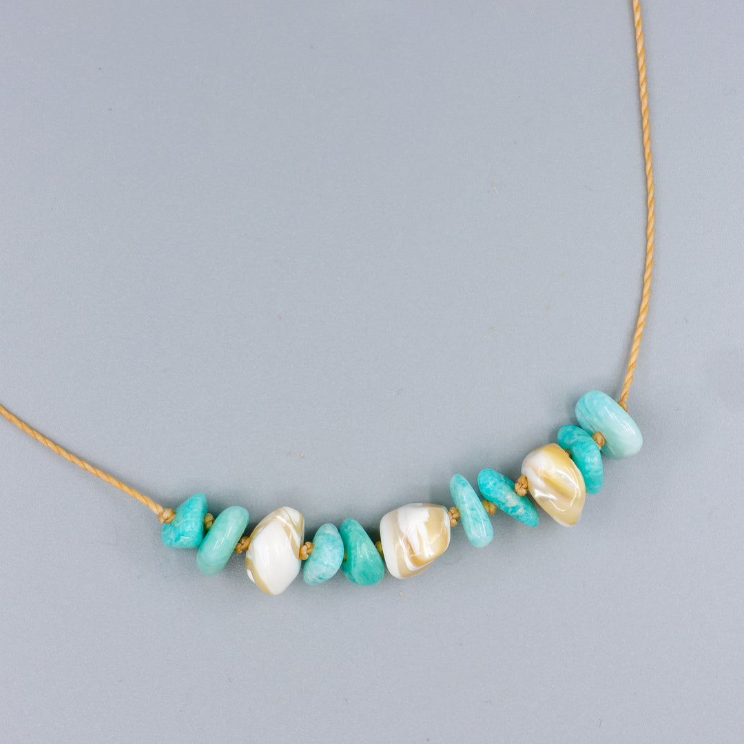 handknotted mother of pearl and amazonite beach inspired necklace with a gold clasp on a gold colored cord