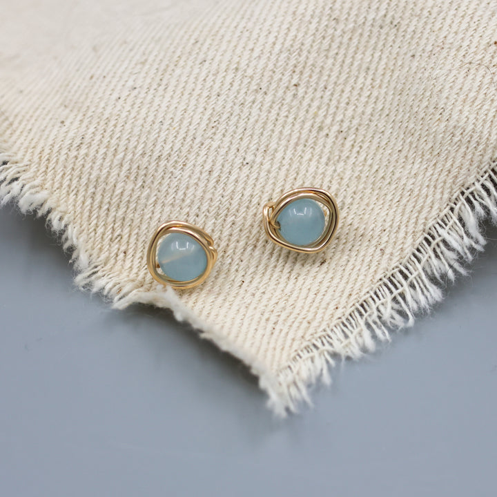 gold fill aqauamarine stud earrings handmade earrings on muslin fabric