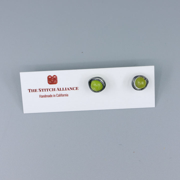 peridot stud earrings wire wrapped oxidized sterling silver on a white card