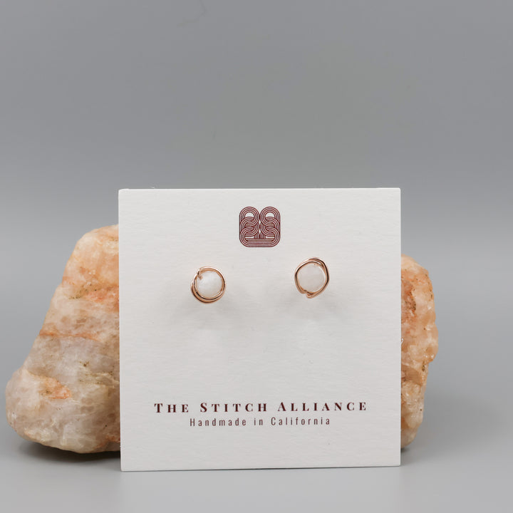 handmade wire wrap rose gold and rainbow moonstone stud earrings on a white card