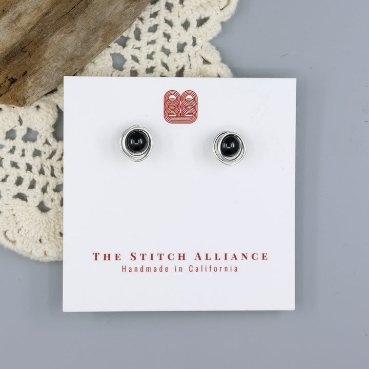 handmade sterling silver and black spinel stud earrings on a white card