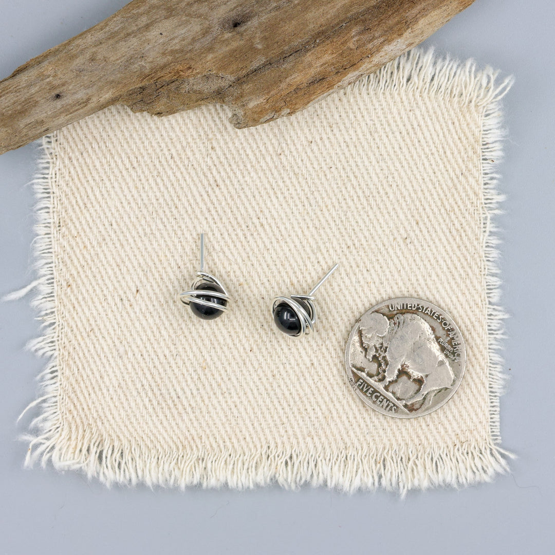 handmade sterling silver and black spinel stud earrings with a nickel for size comparison