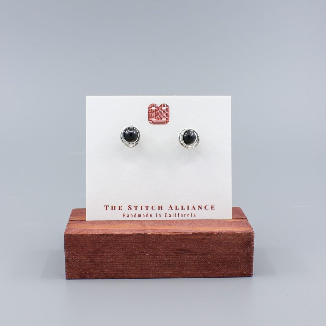 handmade sterling silver and black spinel stud earrings on a white card