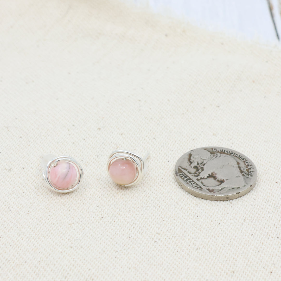 handmade sterling silver pink opal wire wrap stud earrings with a coin for size comparison