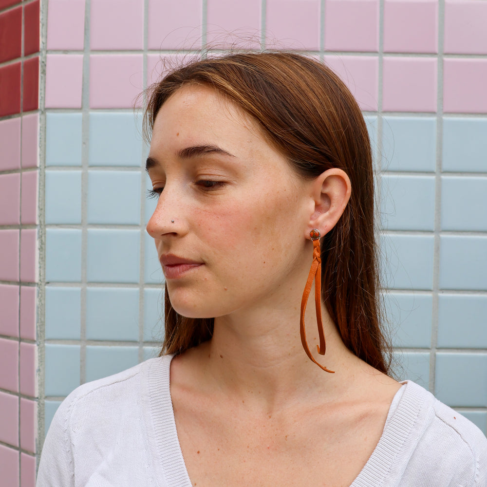 orange copper turquoise and sterling silver earrings with deerskin fringe worn on a model