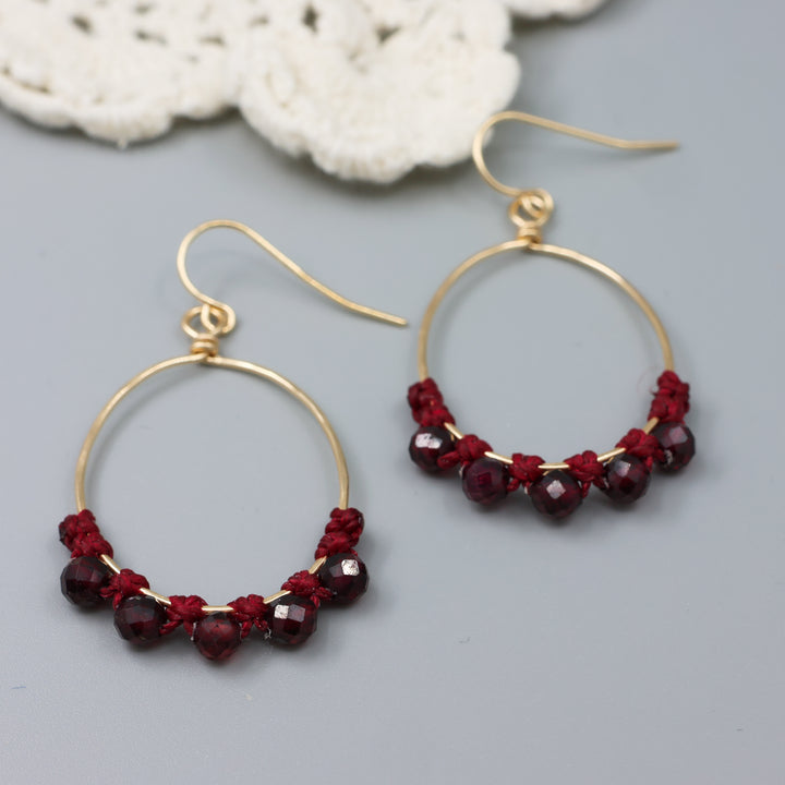 handmade gold macrame hoop earrings with garnet beads detail view