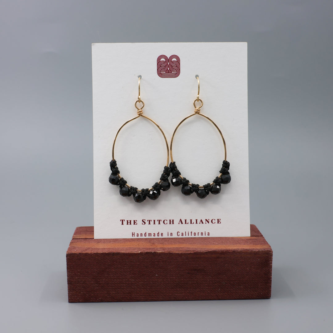 handmade gold hoops with black spinel beads and macrame on a white card